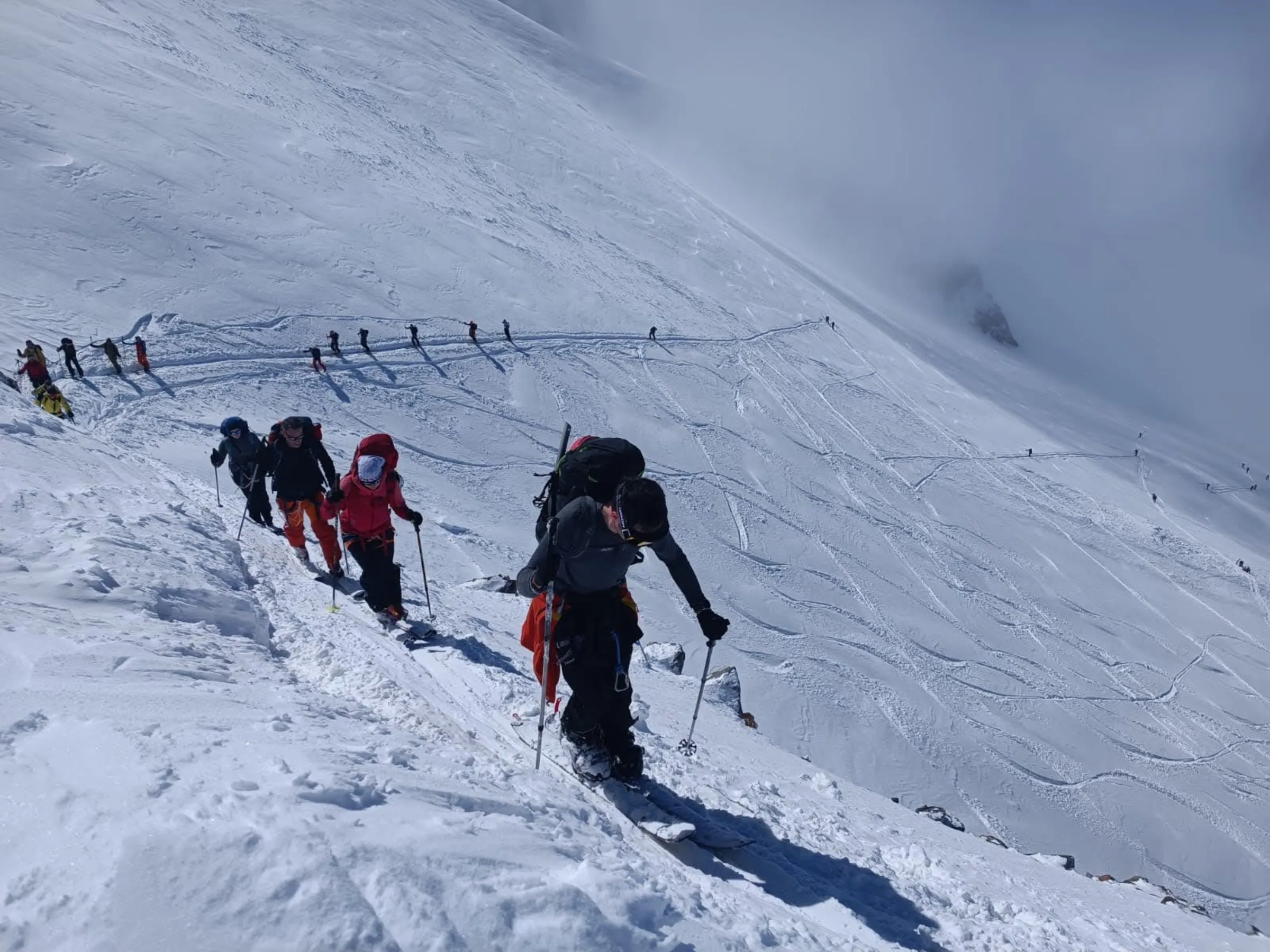 Jan ascending a snowy slope while cross-country snowboarding in the Alps between Chamonix and Zermatt