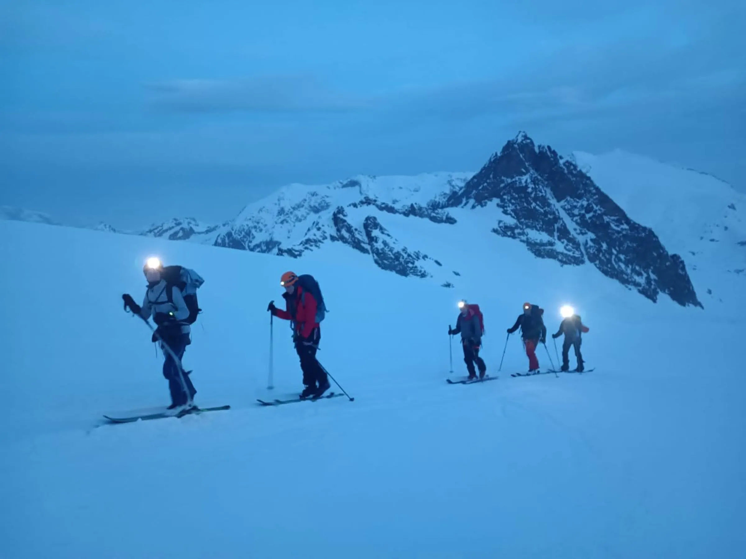 Jan cross-country snowboarding at dawn with headlamps and mountain gear